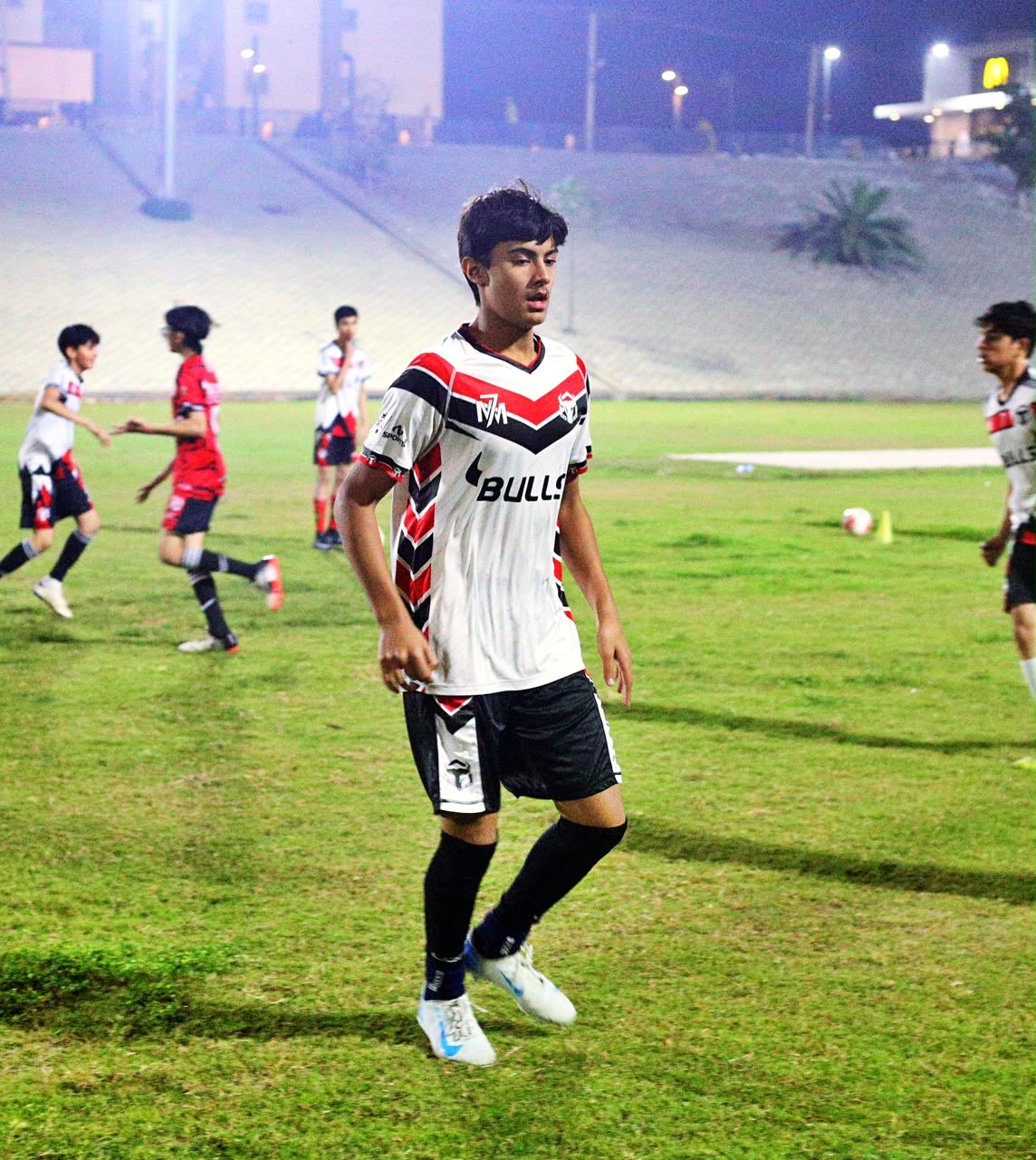 Zavyan Haider walking on the pitch in a white kit